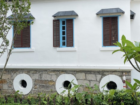 主樓底層基座是特厚的花崗岩石牆，把整座建築升高，更加入牛眼窗，有助通風防潮。