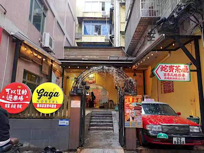 停泊在民宿門口的一輛紅色的士和繁體字招牌，還以為身處香港。