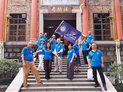 80届畢業生穿着自行創作的T恤在曾經上課教室前合照留念。